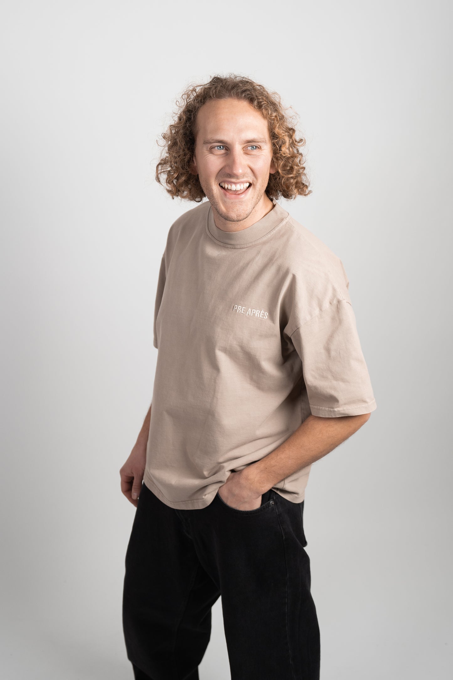 mann modell med en brun t skjorte med hvit skrift på brystet