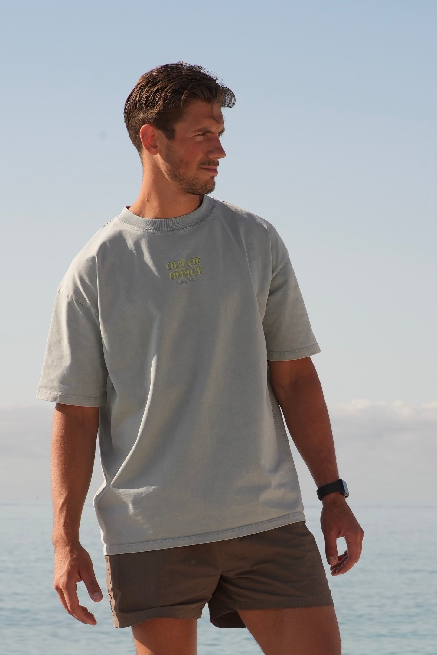 Grå blå t skjorte med lime grønn skrift midt på brystet