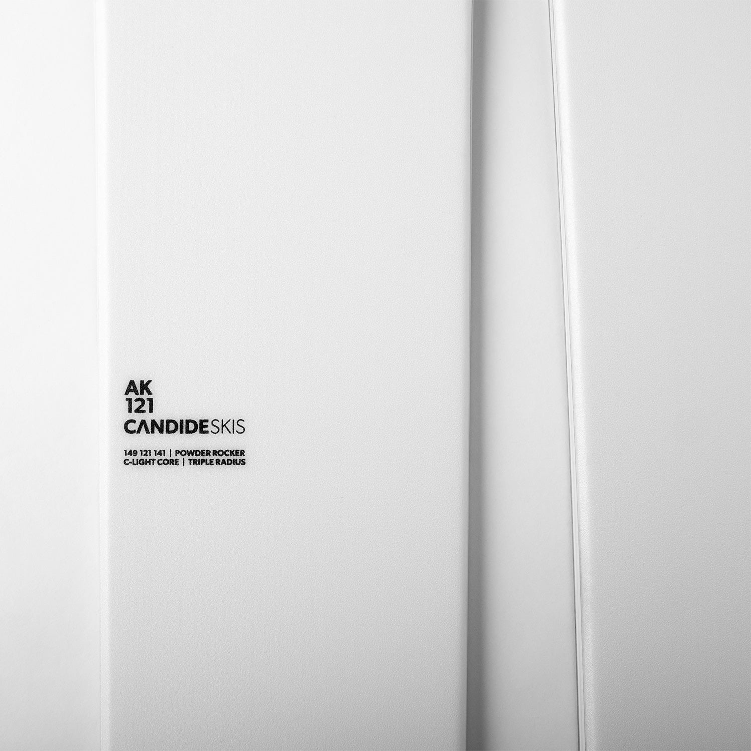 Nærbilde av liten svart skrift på hvite ski, på hvit bakgrunn