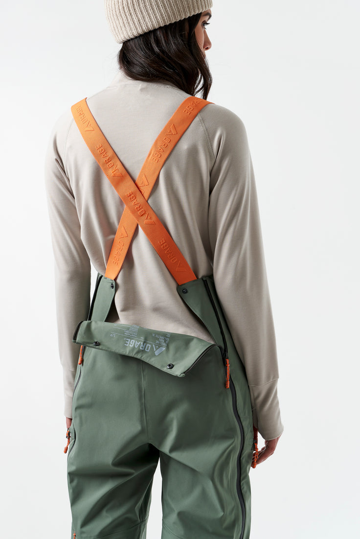 bilde av den grønne ski buksen med oransje stropper som illustrerer hvordan buksen kan opnes på baksiden