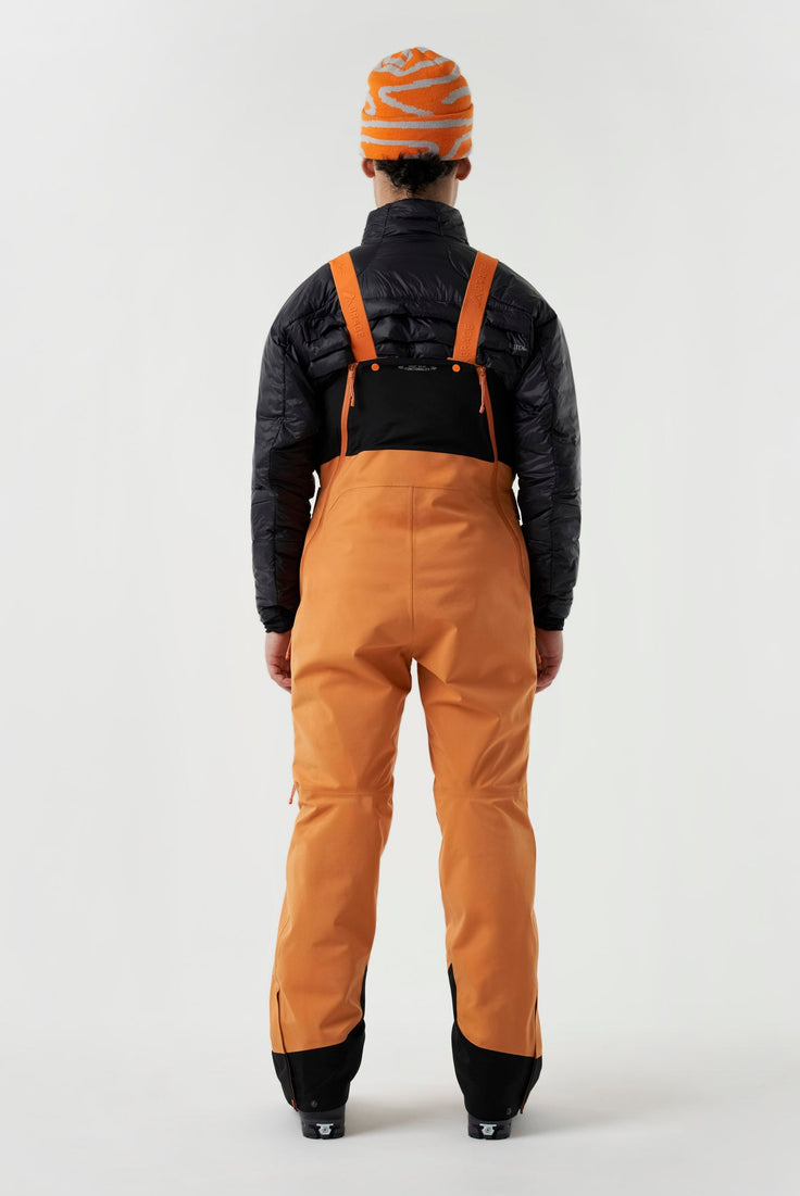 Baksiden av en oransje skibukse med svarte detaljer